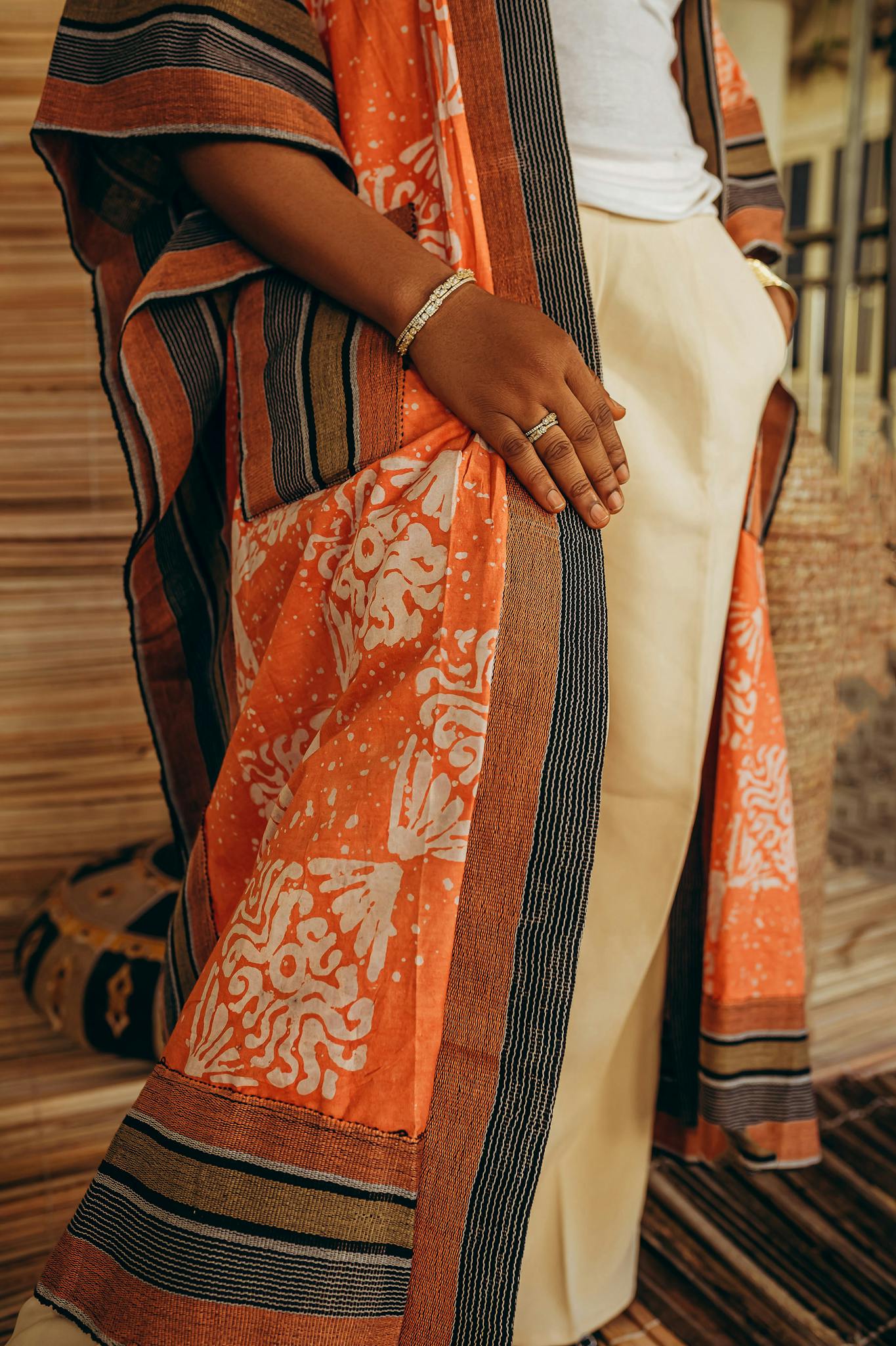 Stylish African-inspired robe in vibrant orange with intricate patterns and stripes.